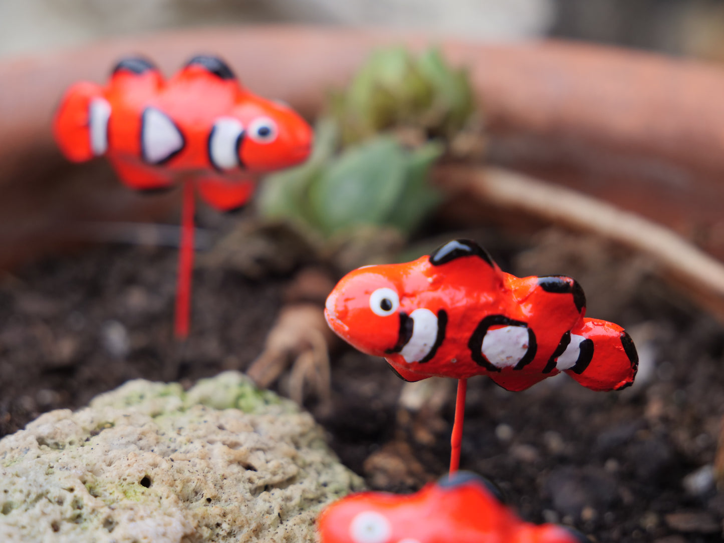 Detailansicht einer Clownfisch-Figur aus Terrakotta mit authentischer Bemalung, perfekte Gartendeko für Miniteiche und maritime Dekoration