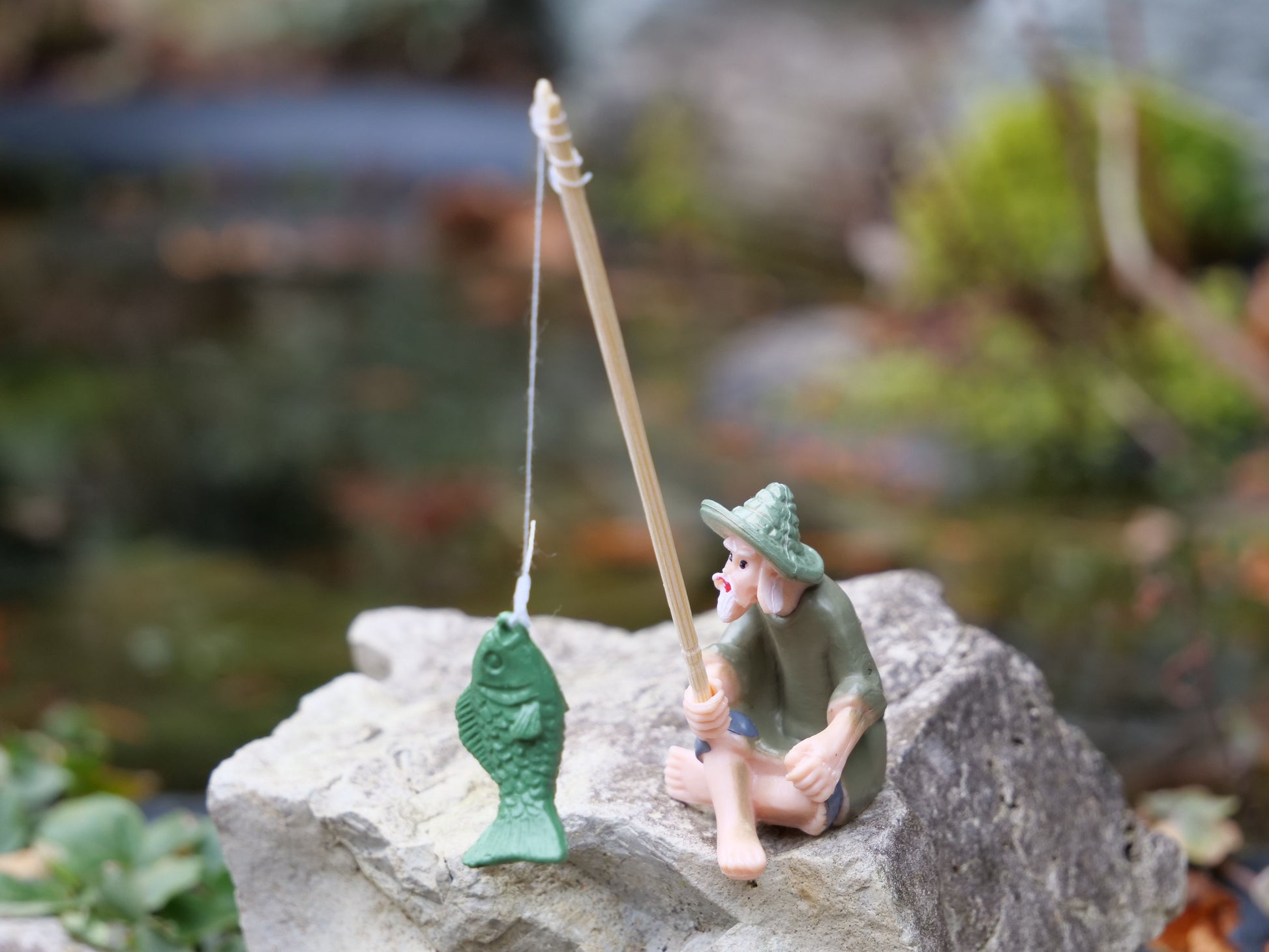 Dekofigur sitzender Fischer mit Angel und grünem Fisch, detailreiche Gartendeko für Miniteiche und Wassergärten